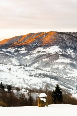 Kış dağ manzaralı şafakta güneş ışınları mounta tepesine Parlatıcı.