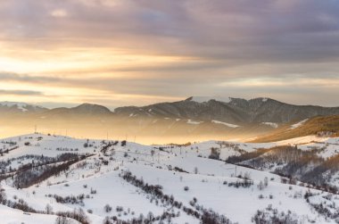 Kış dağ manzaralı şafakta güneş ışınları mounta tepesine Parlatıcı.