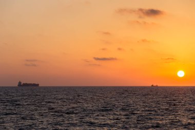 sarı-kırmızı günbatımı manzarası olan Yelkenli deniz üzerinde