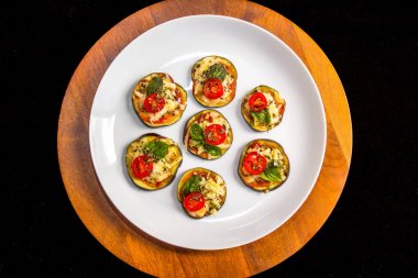 Domates, kekik ve fesleğen ahşap bir Kaide üzerine beyaz bir plaka ile patlıcan bruschetta