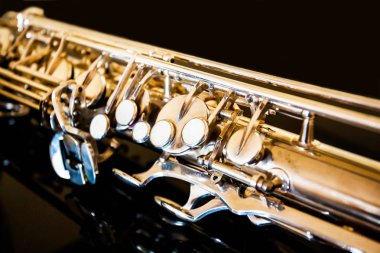 Tenor saksafon. Nefesli klasik araç. Caz, blues klasikleri. Müzik. Saksafon siyah bir arka plan. Siyah ayna yüzey. Müzik tarzı