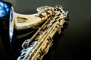 Tenor saksafon. Nefesli klasik araç. Caz, blues klasikleri. Müzik. Saksafon siyah bir arka plan. Siyah ayna yüzey. Müzik tarzı