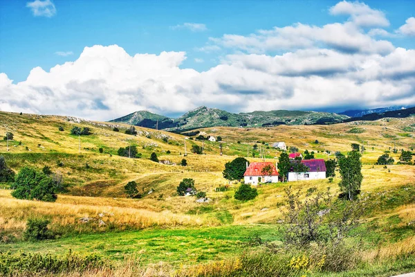 Monténégro, la route passe par le parc national Durmitor. Les fermes sont élevées dans les montagnes. Paysage monténégrin d'été. Ciel bleu et nuages blancs dans les montagnes — Photo