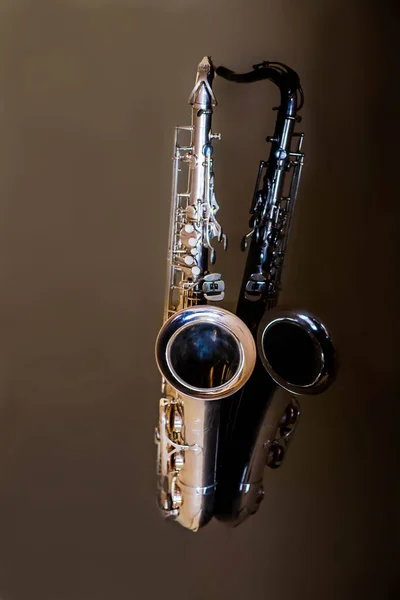 Saxophone tenor. Woodwind Classical Instrument. Jazz, blues, classics. Music. Saxophone on a black background. Black mirror surface. Music styles — Stock Photo, Image