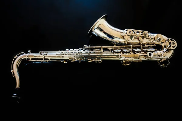 Tenor saxofónico. Woodwind Classical Instrument. Jazz, blues, clásicos. Música. Saxofón sobre fondo negro. Superficie de espejo negro. Estilos musicales —  Fotos de Stock