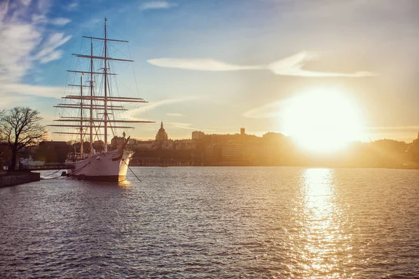 Ancient pirate ship sailing on the ocean at sunset. In full sail. Classic sailing ship with sails lowered at sunset.