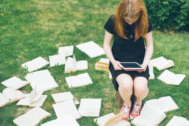 Öğrenme eBook okuyucu ve kitap ile bir kadın. Modern eğitim teknolojisi ve geleneksel yol yöntemi arasında seçim. Dijital tablet pc ve ders kitabı tutan kız. Çağdaş eğitim.