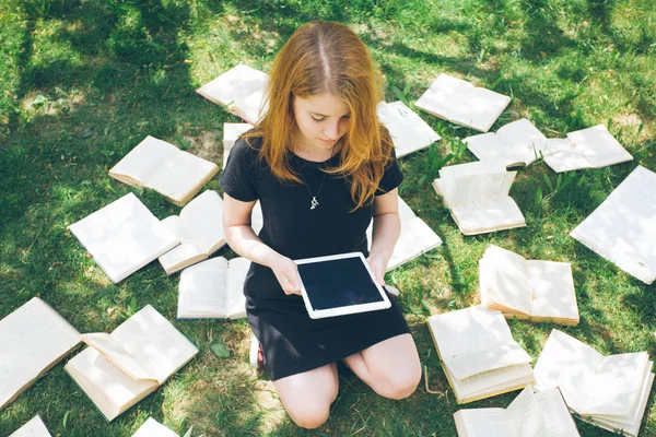 Öğrenme eBook okuyucu ve kitap ile bir kadın. Modern eğitim teknolojisi ve geleneksel yol yöntemi arasında seçim. Dijital tablet pc ve ders kitabı tutan kız. Çağdaş eğitim.