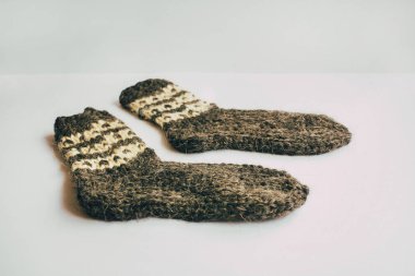 El yapımı sıcak örme çorap yığını eşarplar Mittens üzerinden kaba yün iplik ahşap masa üzerinde kahverengi bej gri. Yakın çekim. Kış sonbahar eko moda akrabalarımıköle stili.