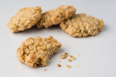 Isırık ve beyaz sayaçta kırıntıları ile dört yulaf ezmeli kurabiye