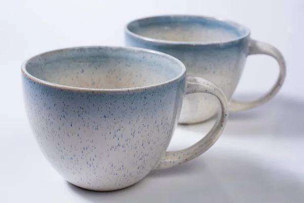 Two Speckled Blue Mugs Isolated on White Close Up