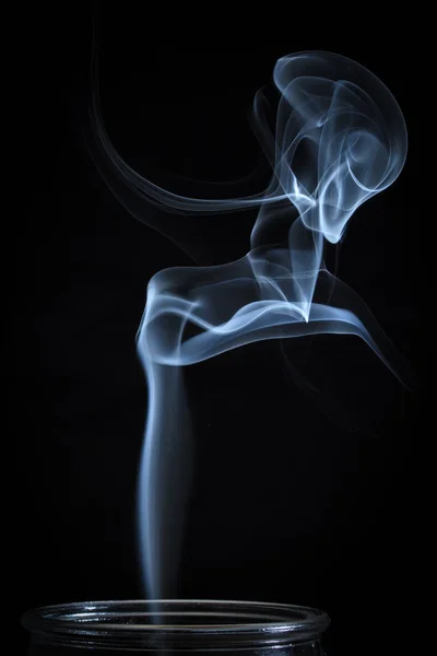 Abstrakter feiner blauer Rauch, der aus vertikalen Flaschenhintergründen strömt — Stockfoto