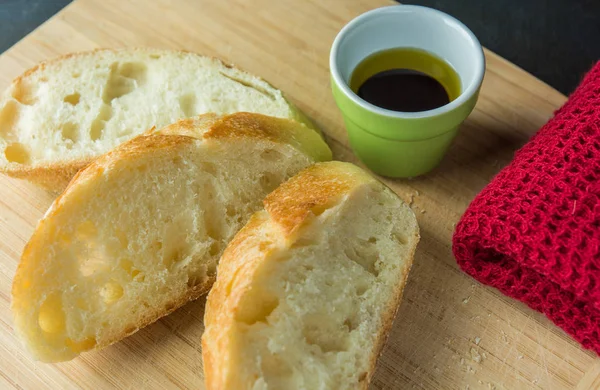 Brotscheiben auf Schneidebrett mit Öl und Tuch — Stockfoto