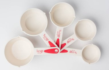 Set of Fanned Measuring Cups on White Background Top View clipart