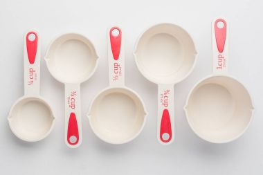 Set of Measuring Cups Staggered on White Background Top View clipart
