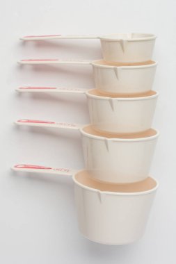 Set of Measuring Cups Stacked on White Background Top View clipart
