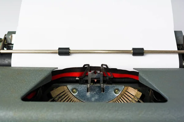 Starožitný psací stroj na bílém pozadí s papírem zblízka — Stock fotografie