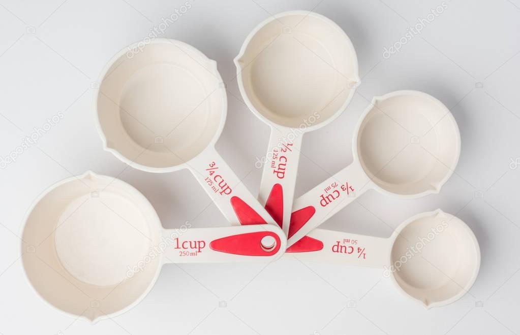 Set of Fanned Measuring Cups on White Background Top View