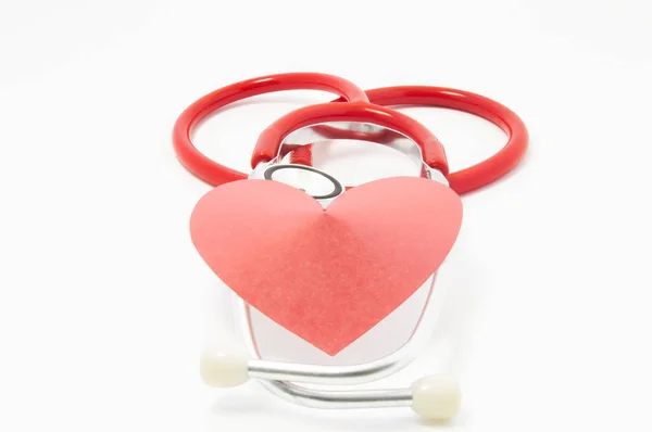 Stetoscopio e cuore di velluto rosso si trovano l'uno sull'altro su sfondo uniforme bianco. Foto per l'uso in cardiologia, salute del cuore, apparecchiature diagnostiche cardiache, diagnosi e trattamento di malattie cardiache — Foto Stock