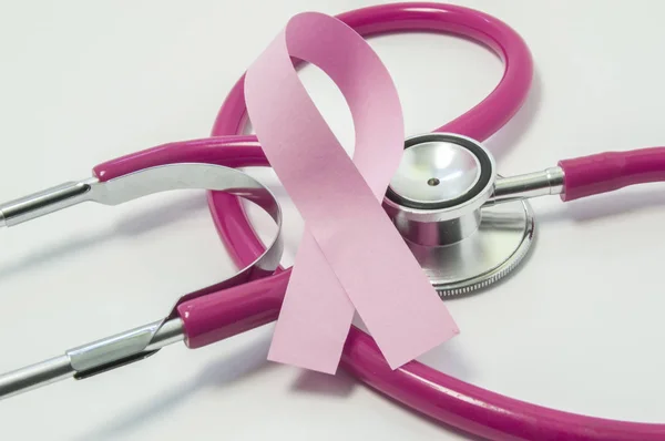 Concetto di cancro al seno. Nastro rosa vicino allo stetoscopio rosa-viola medico dello screening mammario, che simboleggia la diagnosi, il trattamento, la lotta, la consapevolezza e il sostegno del cancro al seno delle donne da vicino — Foto Stock