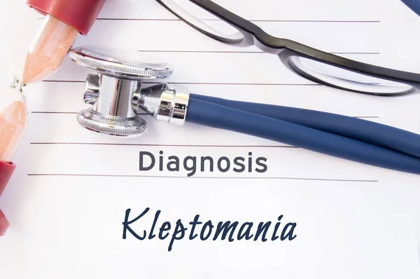 Diagnose kleptomanie. Psychiatrische diagnose Kleptomanie is geschreven op papier, op die vaststellen stethoscoop en zandloper voor het meten van de tijd aan onderzoek. Concept foto voor psychiatrie of psychologie — Stockfoto