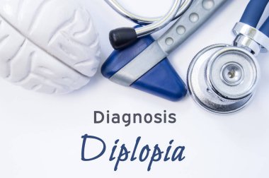 Diagnosis of Diplopia. Anatomical brain figure, neurological hammer and stethoscope lying on sheet of paper or book with the title neurological diagnosis of Diplopia. Concept for neurology clipart