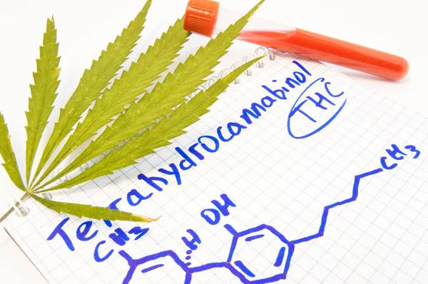 Test o analisi per la presenza di tetraidrocannabinolo (THC) nel sangue. Foglia di canapa, provetta giaceva vicino alla nota con il titolo di alcaloide della cannabis Tetraidrocannabinolo e trasse la sua formula chimica — Foto Stock