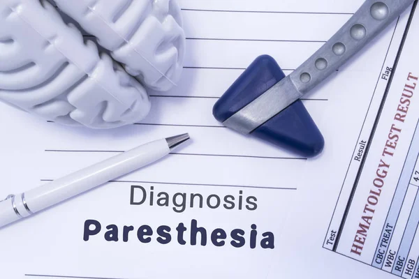 Diagnose paresthesie. Figuur hersenen, neurologische hamer, afgedrukt op een papier-bloedonderzoek en diagnose van paresthesie geschreven in de medische vorm is liggend op de tafel in de arts neuroloog kabinet — Stockfoto