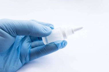 Doktor el, plastik şişe ya da ilaç - kapsayıcıyla tutarak göz, kulak veya burun damla mavi eldiven içinde giyinmiş. KBB veya göz hastalıklarının tedavisinde için konsept fotoğraf ilaç klinik araştırmaları için hazırlık