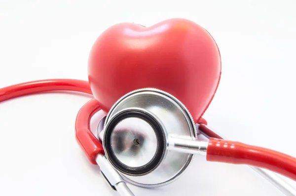 Rotes Stethoskop oder Phonendoskop mit verchromtem Bruststück führt die Vermessung der Herzfigur von vorne durch. Konzept zum Schutz, zur Behandlung und Prävention des Herzens vor Herz-Kreislauf-Erkrankungen — Stockfoto