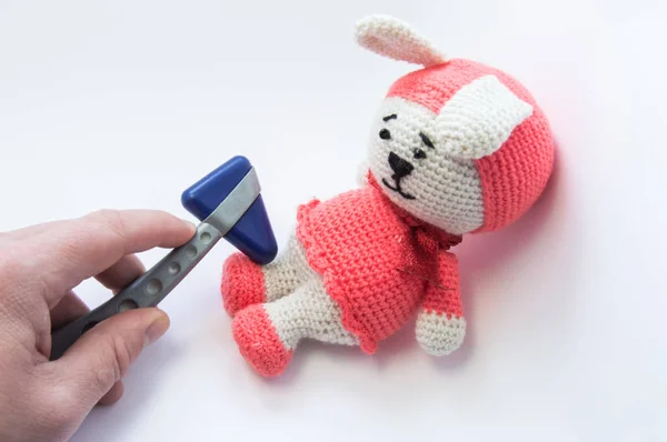 Doctor examines soft rabbit toy with neurological hammer and checks reflexes in feet. Concept for neurological examination of neurologist condition of nervous system children or infants in Pediatrics — Stock Photo, Image