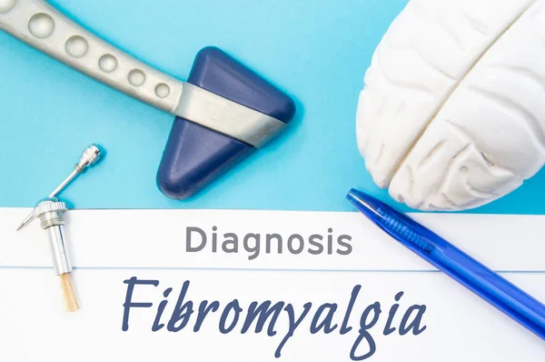 Neurologische diagnose van fibromyalgie. Neurologische hamer, menselijk brein figuur, hulpmiddelen voor het testen van de gevoeligheid zijn op tafel om het volgende te titel van tekst diagnose van het fibromyalgie in de werkplaats van neuroloog — Stockfoto