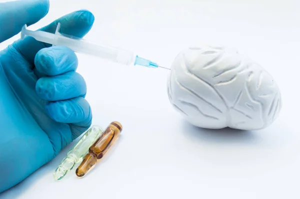 Doctor conducts brain treatment by injecting medication using syringe in 3D model organ. Concept photo symbolizing process of treatment of brain diseases - parkinson's, stroke, tumor, atherosclerosis — Stock Photo, Image