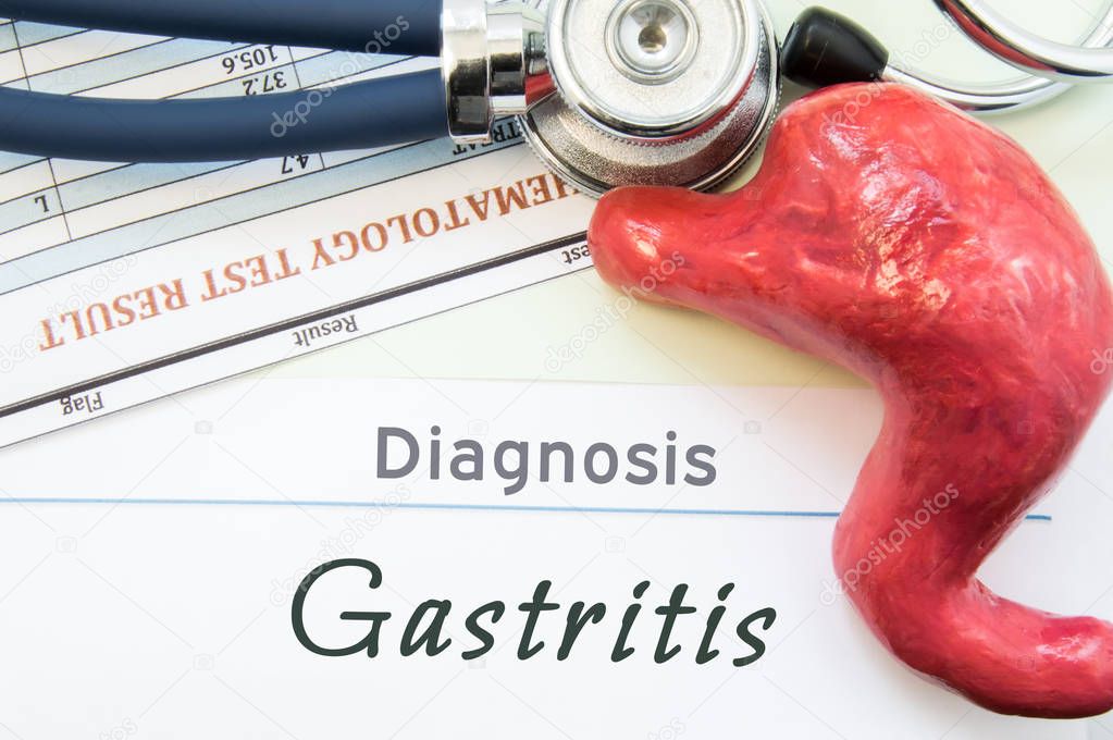 Model of stomach, blood test and stethoscope lying next to written title on paper diagnosis Gastritis. Concept photo of causes, diagnostic, treatment and prevention of gastric Gastritis