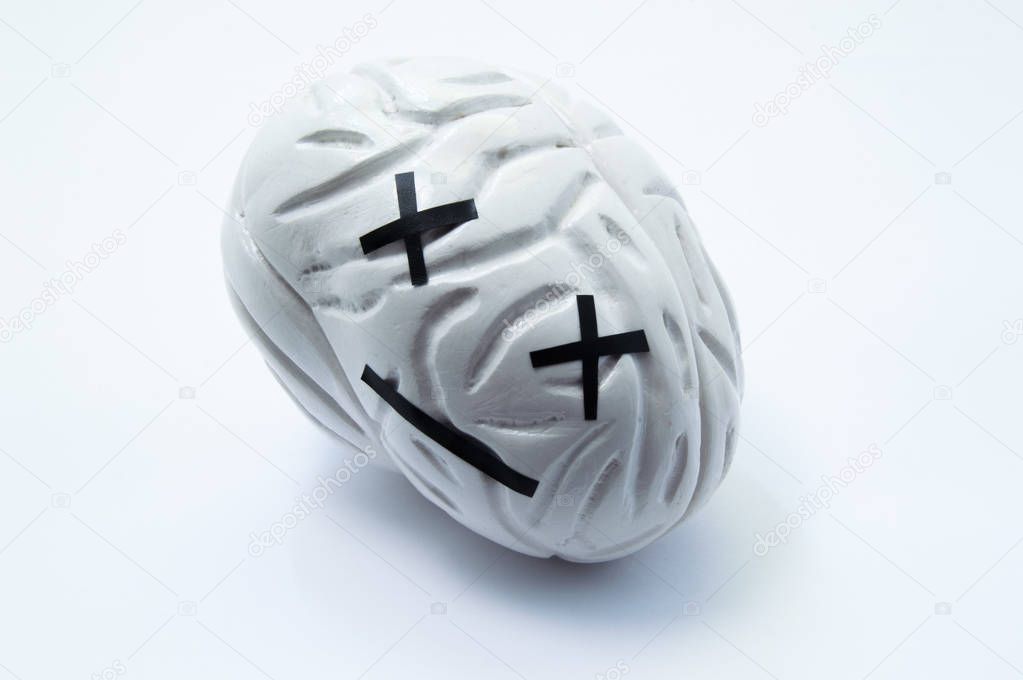 Concept photo of death, critical injury, damage or dead human brain. Model of brain with emotion dead smile symbolizes serious disease, death or failure of function in coma, stroke, edema, dementia