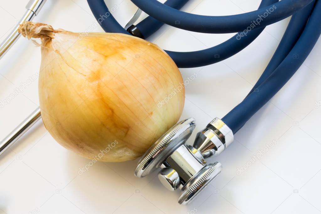Onion and stethoscope. Stethoscope tests onion for presence of GMO, diseases of vegetable, varieties. Nutrition and health benefits of onions as organic or healthy food for health, for use in medicine