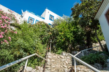 Marmaris sokakları fotoğraflar. Çalılıkları çalılar ve yeşil ile mavi ahşap kepenkleri pencere pervazına Marmaris, Türkiye'de Tepedeki Ev için üsten taş merdiven