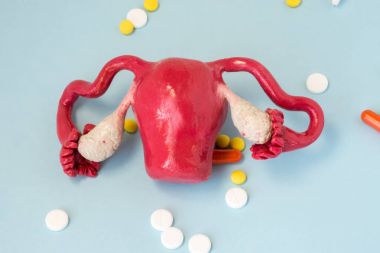 Fotoğraf hastalıkların rahim, yumurtalık, serviks, kadın üreme sisteminin diğer bozukluklar ilaç tedavisinin anlayışı. Rahim üzerinde mavi arka plan, ilaç ilaçlar tarafından çevrili modeli