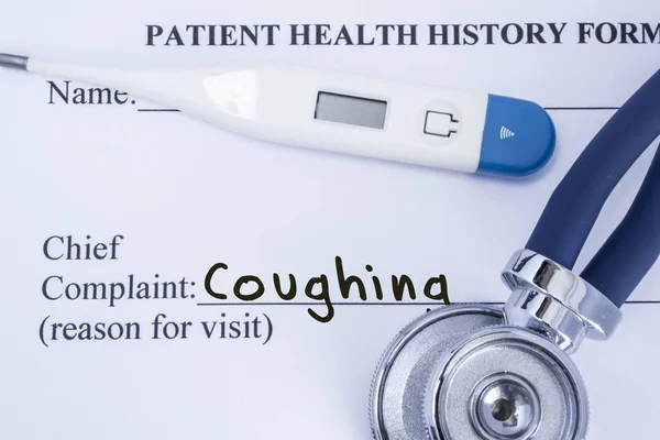 Chief complaint coughing. Paper patient health history form, on which is written the complaint coughing as the main reason for visit to the doctor, with a thermometer and stethoscope — Stock Photo, Image