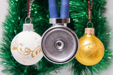 Sağlık stetoskop membran anteriorly Noel ağacı süsleme ile arka plan bulanık topları çevrili iki tüp ile. Noel ve yeni yıl tıp kavramı kartı
