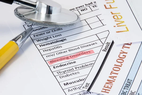 Photo from scene of doctor working place with bleeding disorder. Highlight symptom bleeding disorder in patient medical history is near stethoscope, blood test and biochemical test of liver functions — Stock Photo, Image