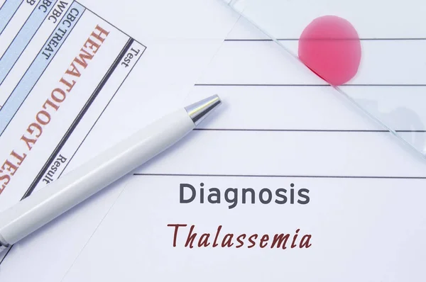 Diagnose thalassemie. Geschreven door arts hematologische diagnose thalassemie in medische verslag, dat zijn resultaat van bloedonderzoek en glasplaatje met bloed uitstrijkjes voor lab onderzoek — Stockfoto