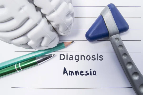 Neurologische diagnose van amnesie. Neurologische reflex hamer, vorm van de hersenen, pen en het potlood op een medisch rapport, aangeduid met de diagnose van amnesie. Concept voor neurologie — Stockfoto