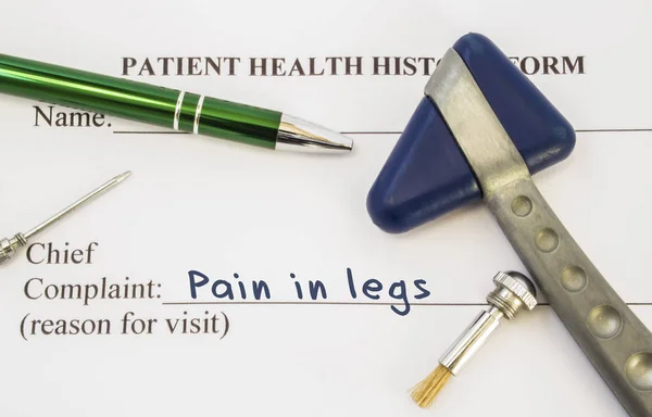 Skarga ból w nogach. Historia zdrowia pacjenta jest na stole, neurologa, który zawiera skargi ból w nogach, otoczony przez młotek neurologiczny, Pędzel i igły, aby określić wrażliwość skóry — Zdjęcie stockowe