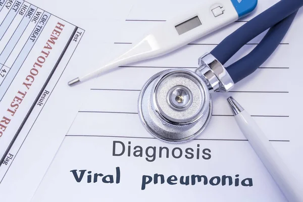 Diagnosis of viral pneumonia. Stethoscope, electronic thermometer, common blood test results are on medical form, which indicated diagnosis of viral pneumonia. Concept for internal medicine physician