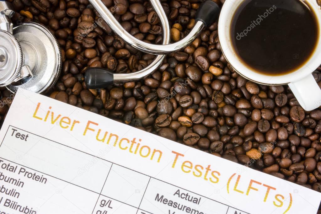 Influence of coffee or caffeine on liver functions, enzymes, activity. Result of liver function test examination near mug with coffee, stethoscope and glasses in  background roasted coffee beans