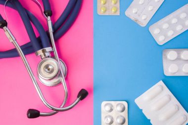 Hap, uyuşturucu, medictions ve blister ambalaj içinde fitil ve iki renk arka planda sağlık stetoskop: mavi ve pembe. İlaç tedavisi, tedavi, kadın ve erkek hastalıkları tedavi kavramı