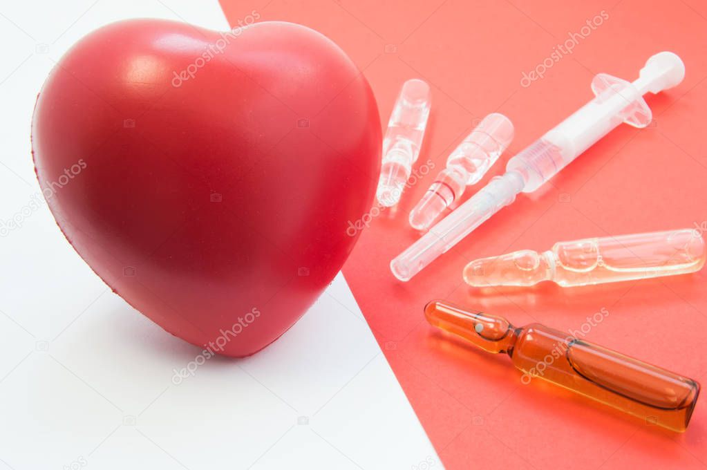 Treatment, support with medication and heart protection. Drugs - vials and syringe on red background aimed at heart, which lies nearby. For use in cardiology and treatment of cardiovascular system