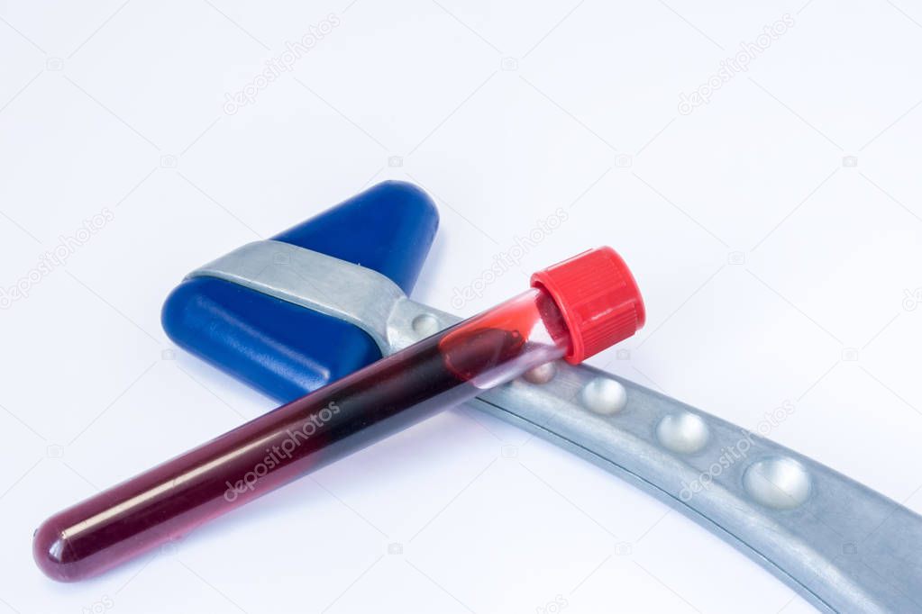 Laboratory test tubes with blood lying on the neurological rubber reflex hammer on a white background. Laboratory diagnosis for diseases of the human nervous system