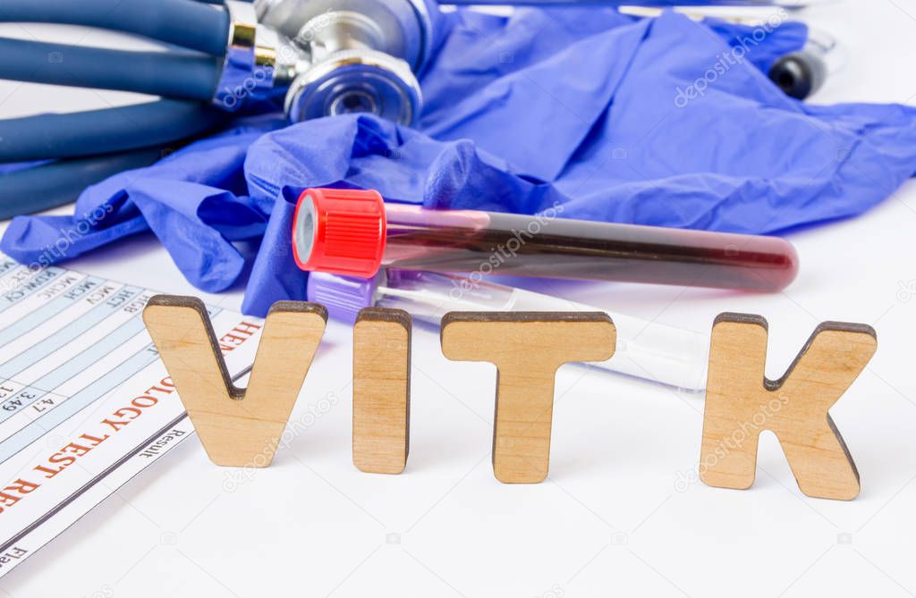Vit K vitamin K acronym or abbreviation diagnostics or medical laboratory test photo concept. Word Vit K is background of blood sample in test tube, protective gloves and hematological blood analysis